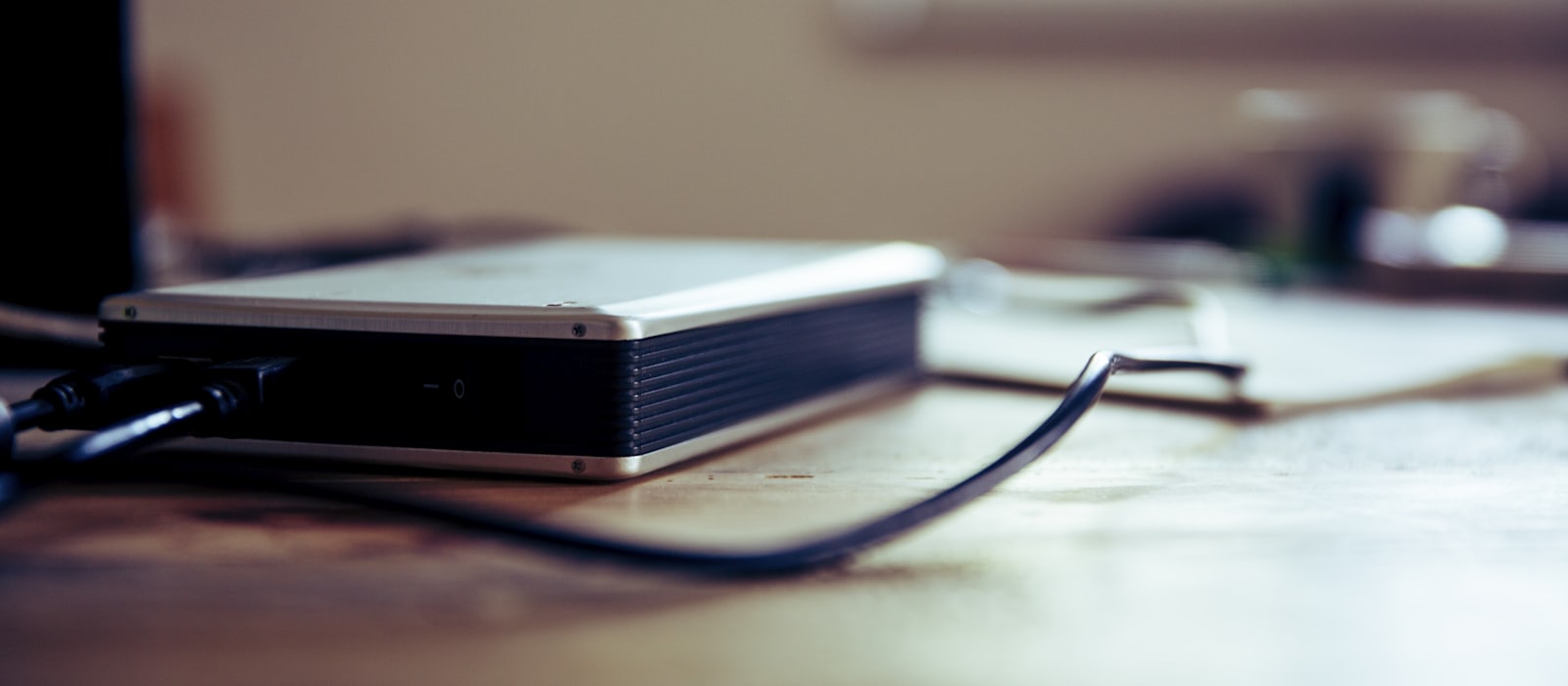 An external hard drive connected on a wooden desk