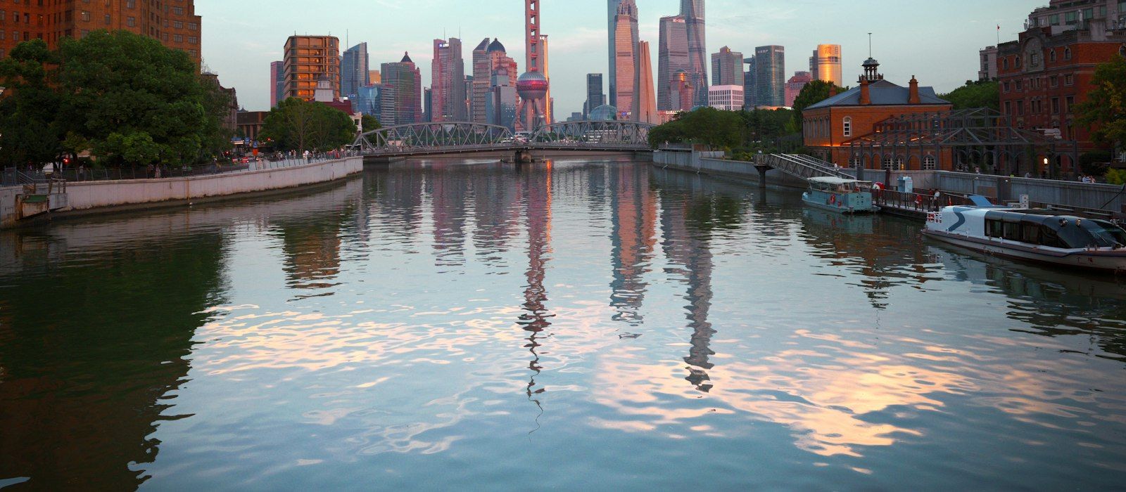 Shanghai skyscrapers reflected in a calm river at dusk
