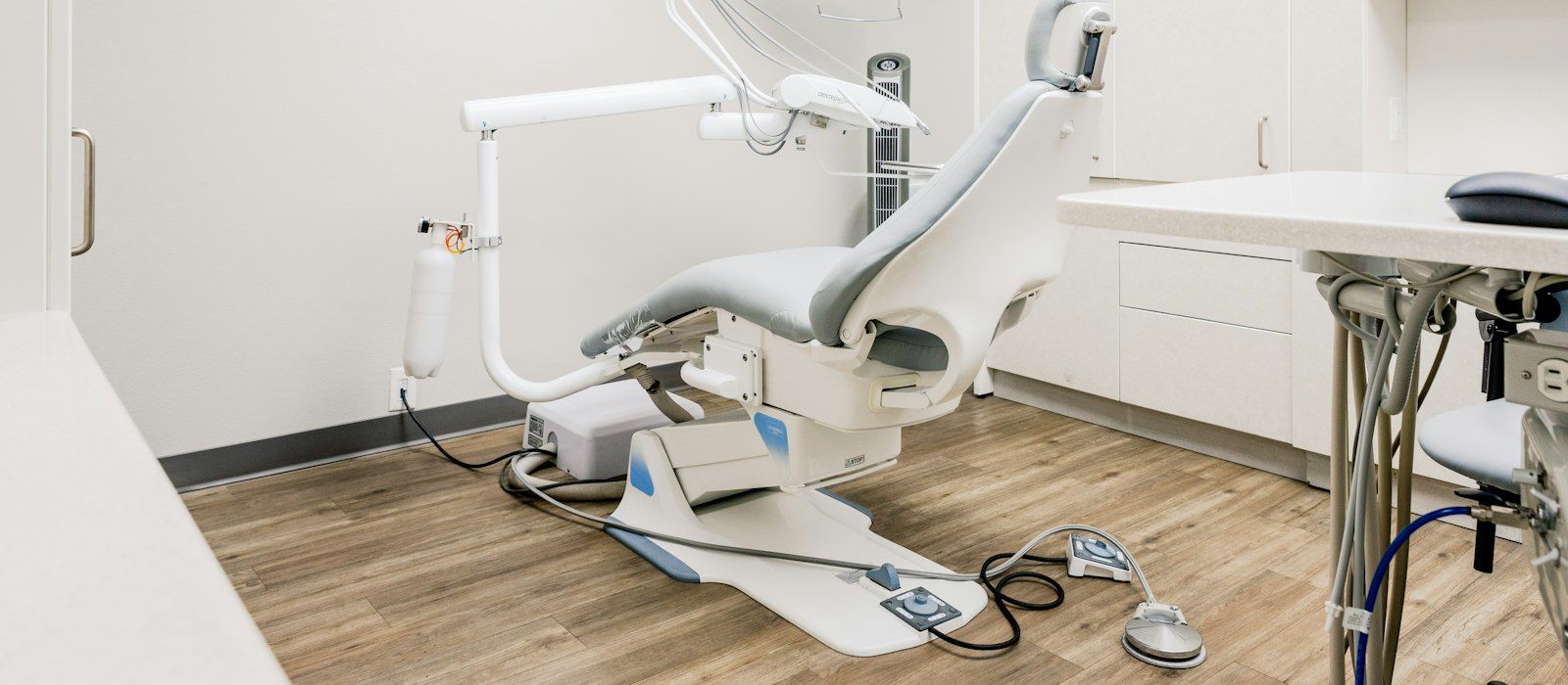 An empty dental treatment chair in a bright, clean clinic room