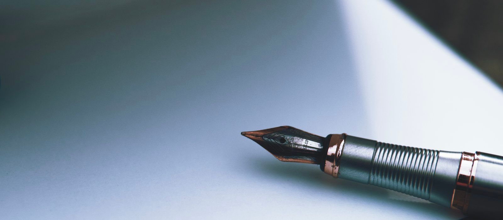 A fountain pen resting on a sheet of white paper