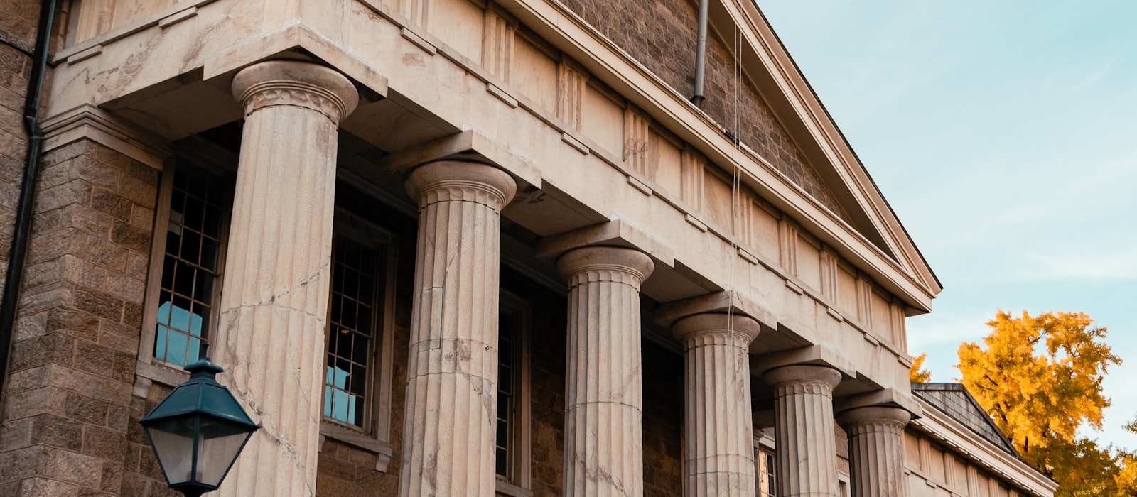 A classical courthouse colonnade seen from below against a clear sky
