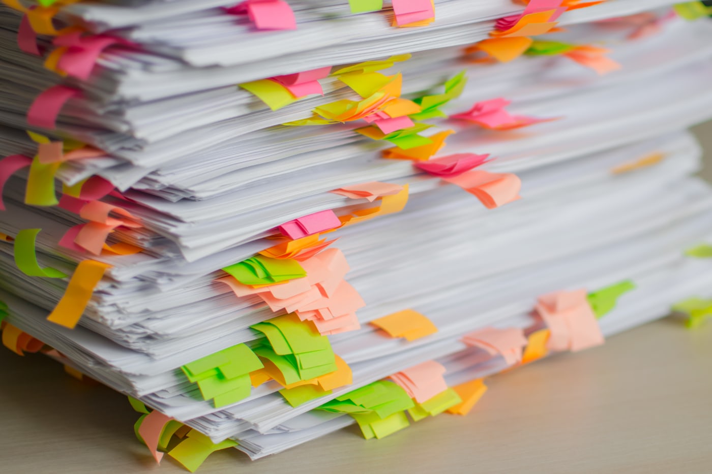A tall stack of documents indexed with coloured tabs