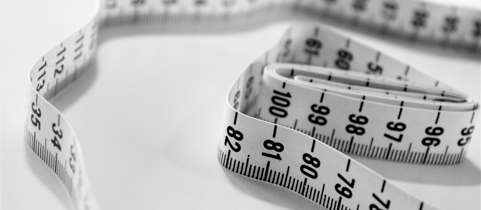 A coiled measuring tape marked in fine gradations
