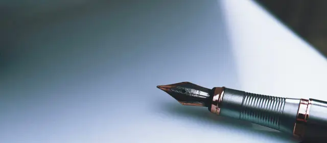 A fountain pen resting on a sheet of white paper
