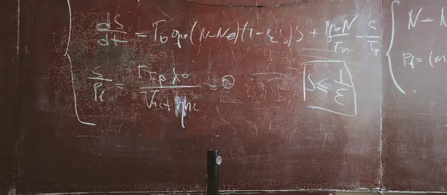 A worn blackboard covered in handwritten equations