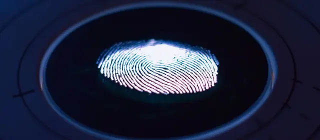 A fingerprint glowing on a circular biometric scanner