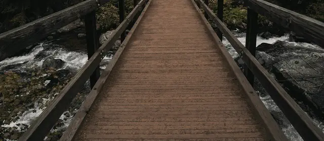 A wooden footbridge crossing a rocky mountain stream