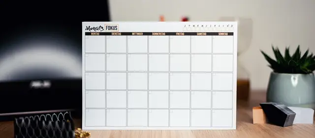 A blank monthly calendar card standing on a desk