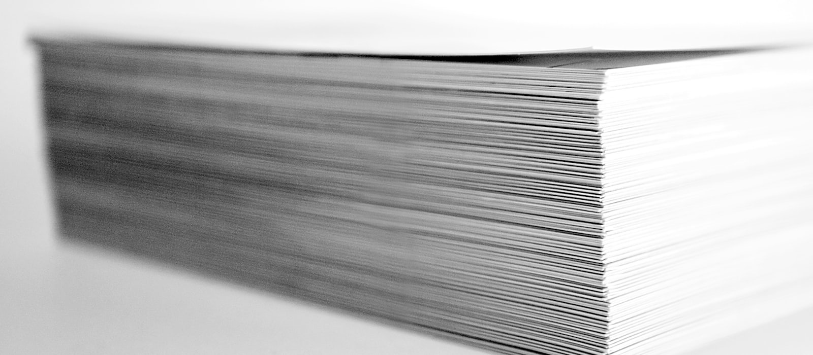 A thick stack of blank paper on a pale surface